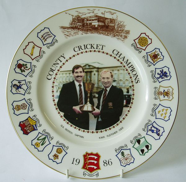 A Coalport china plate decorated with a central design of Graham Gooch and Keith Fletcher holding the trophy. The outer rim incorporates an image of the pavilion, the Essex county badge and the other sixteen county badges.