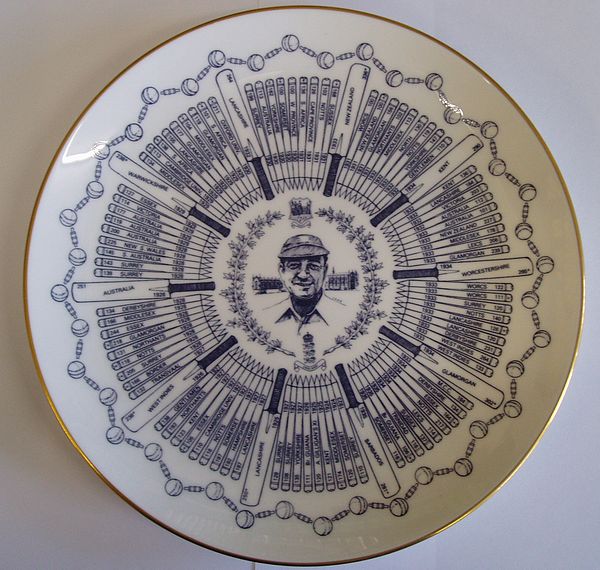 A Coalport china plate bearing a central portrait of Walter Hammond, encircled by bats and stumps, each containing details of one of his hundred first-class centuries. The design is completed by a border of balls and bails and edged in gold.