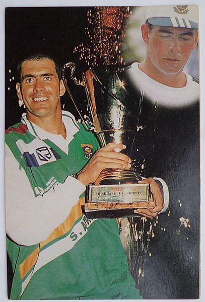 An original half-quarter length colour postcard photograph of Hansie Cronje holding a trophy.