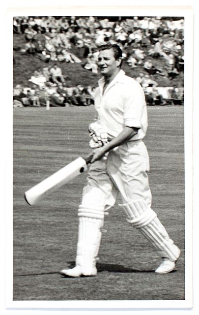 An original full-length postcard-size photograph of Keith Miller walking out to bat.