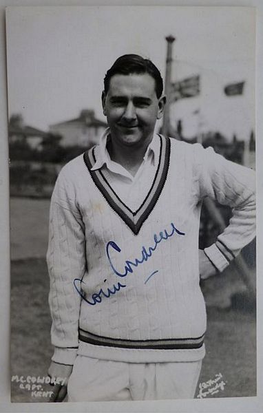 An original three-quarter length postcard photograph of Colin Cowdrey leaning on a bat.