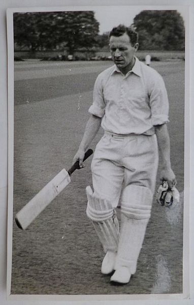 An original full-length postcard-size photograph of Alan Wharton walking off the field.