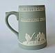 A heavy pale green Jasper Ware china mug, the body moulded in relief in white, titled: Worcestershire County Cricket Club Champions 1964.